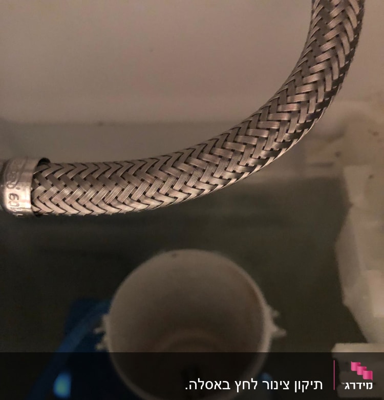 צינור מתכת קלוע בתוך מיכל מים